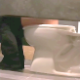 An unsuspecting girl is recorded taking a piss in a public restroom from several perspectives on the other side of the stall wall. Peeing only. Over a minute.